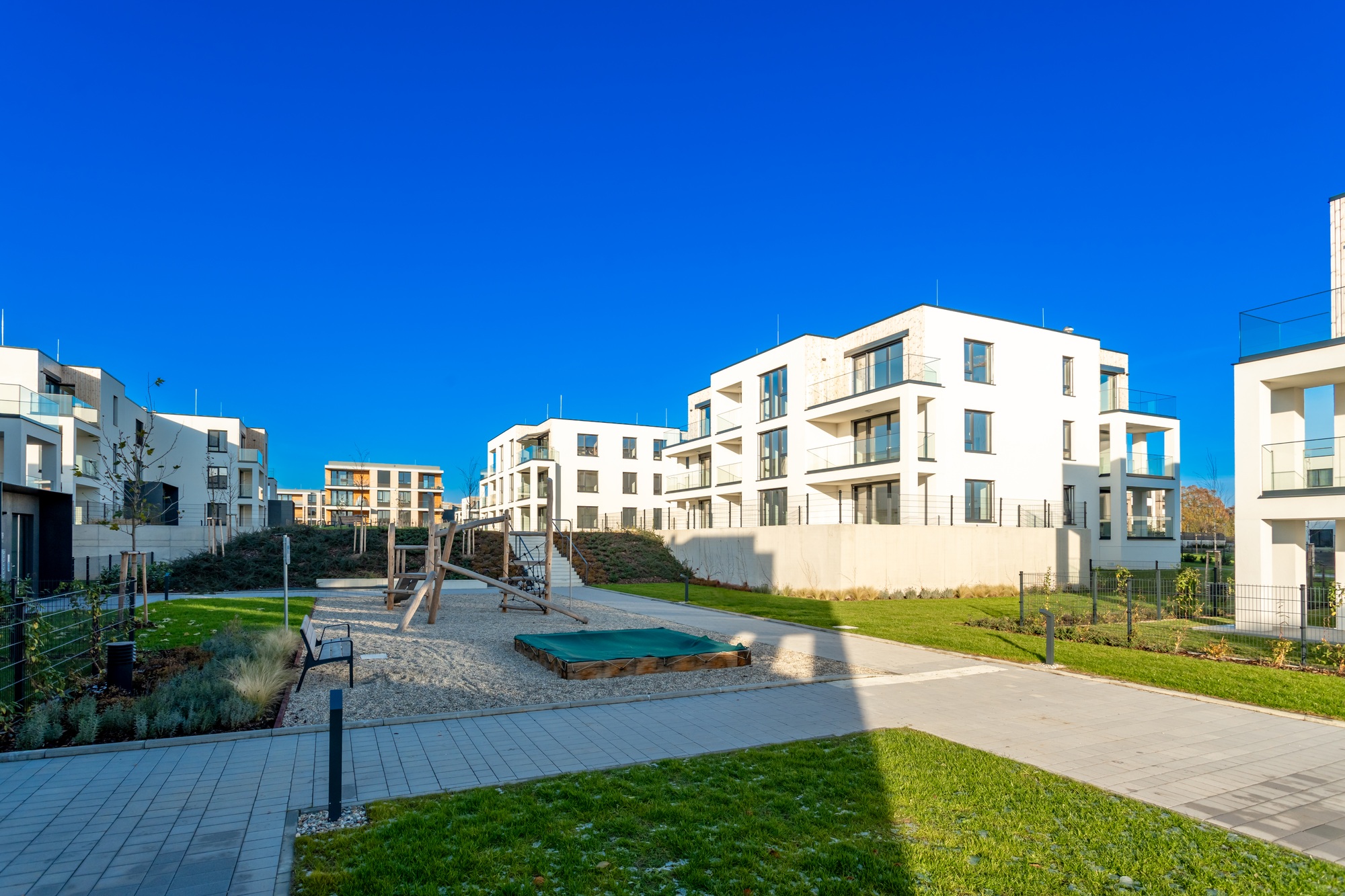 Modern residential complex with playground on sunny day