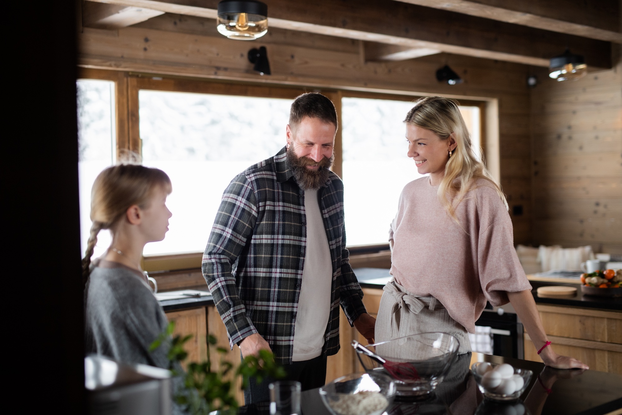 Family with small daughter cooking indoors, winter holiday in private apartment